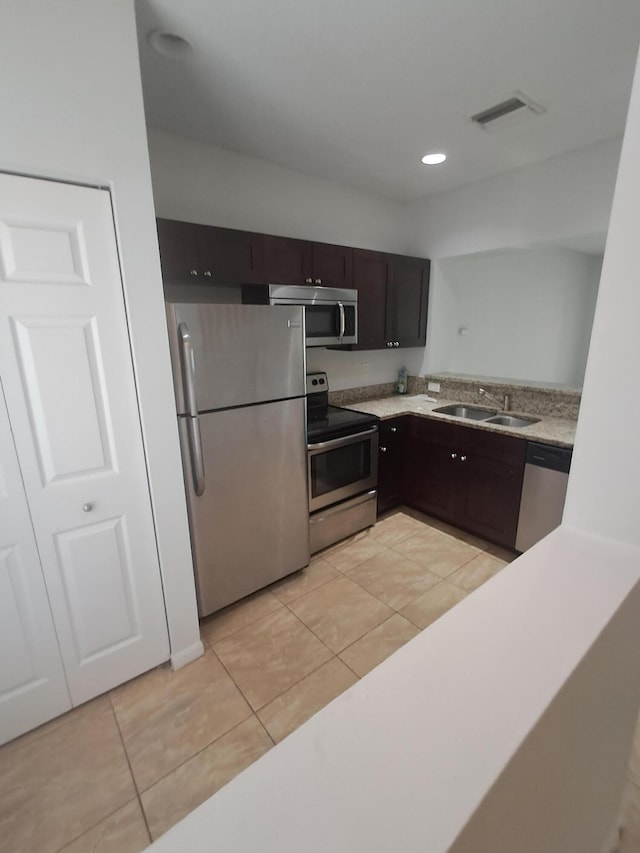 4964 Palmbrooke Cir, West Palm Beach, FL 33417 - kitchen featuring appliances with stainless steel finishes, light tile patterned floors, dark brown cabinetry, and a sink