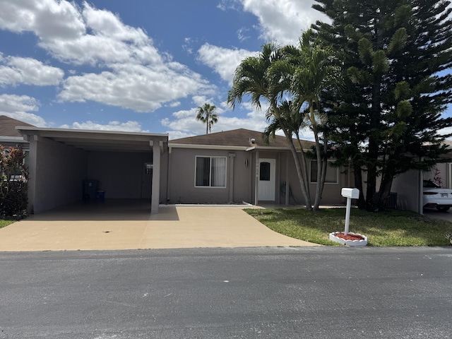 14814 Wildflower Ln, Delray Beach, FL 33446 - view of front of property with stucco siding, a carport, and driveway
