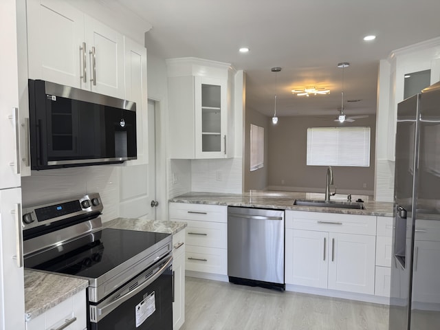 14814 Wildflower Ln, Delray Beach, FL 33446 - kitchen featuring appliances with stainless steel finishes, a sink, ceiling fan, white cabinetry, and light stone counters