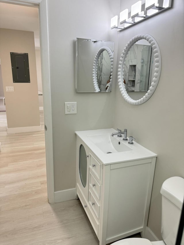 14814 Wildflower Ln, Delray Beach, FL 33446 - bathroom featuring electric panel, toilet, wood finished floors, baseboards, and vanity