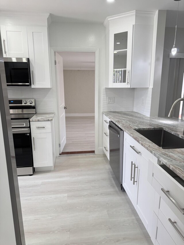 14814 Wildflower Ln, Delray Beach, FL 33446 - kitchen with appliances with stainless steel finishes, a sink, light stone counters, light wood finished floors, and baseboards