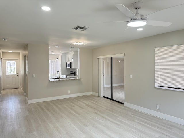 14814 Wildflower Ln, Delray Beach, FL 33446 - unfurnished living room with a ceiling fan, light wood-style flooring, baseboards, recessed lighting, and a sink
