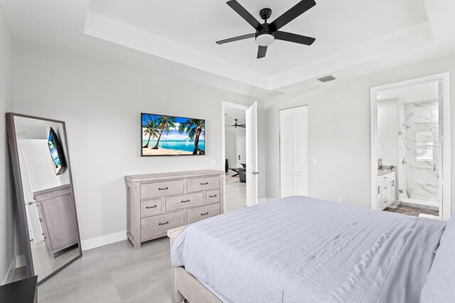 12111 Sugar Pine Trl, Wellington, FL 33414 - bedroom with a raised ceiling, baseboards, ensuite bath, and a ceiling fan