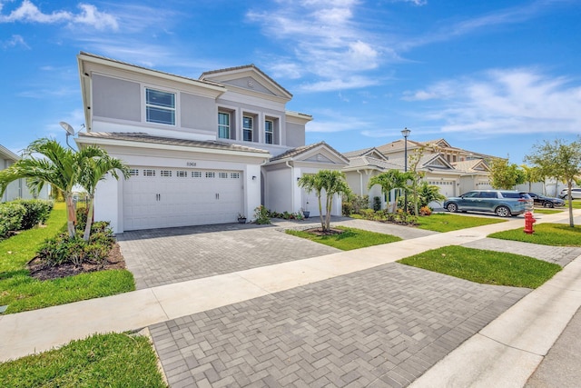 5968 Jasmine Ln, Westlake, FL 33470 - view of front facade with decorative driveway, a garage, stucco siding, and a tiled roof