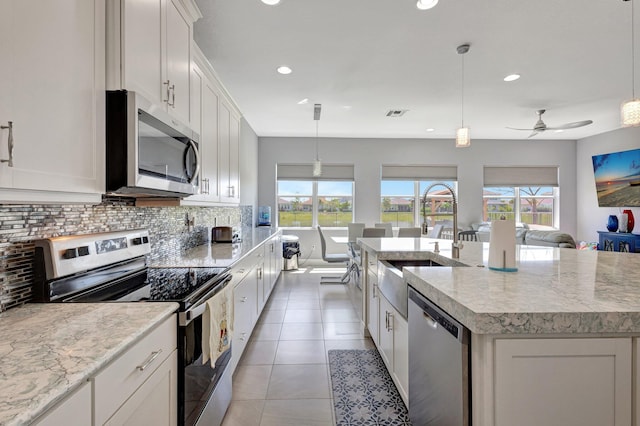 5968 Jasmine Ln, Westlake, FL 33470 - kitchen featuring appliances with stainless steel finishes, open floor plan, a sink, healthy amount of natural light, and recessed lighting