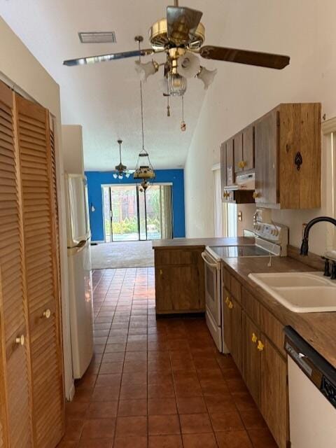 kitchen featuring white appliances, a sink, ceiling fan, under cabinet range hood, and dark tile patterned floors