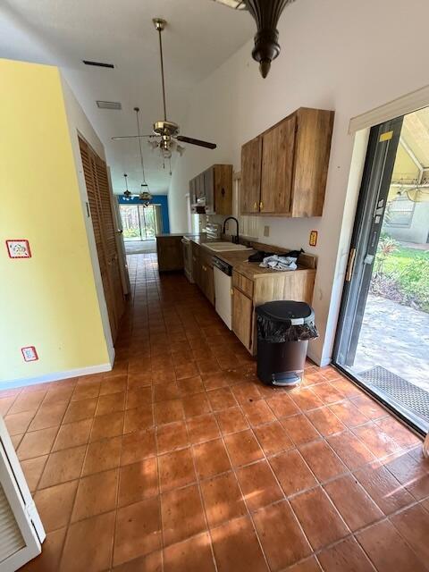 kitchen with dishwasher, ceiling fan, tile patterned flooring, brown cabinets, and a sink