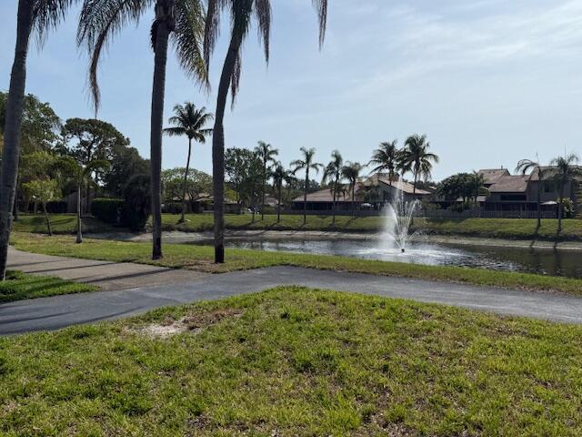 view of community with a water view and a lawn