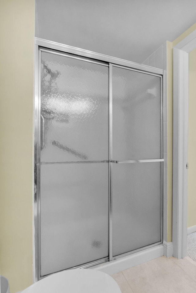 bathroom with a shower stall and tile patterned floors