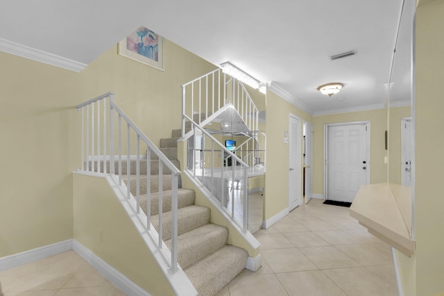 entrance foyer featuring crown molding, tile patterned flooring, baseboards, and stairs