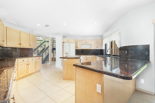 kitchen featuring light brown cabinets, a sink, light tile patterned floors, white refrigerator with ice dispenser, and recessed lighting