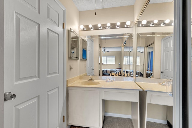 ensuite bathroom with vanity, a ceiling fan, and a textured ceiling