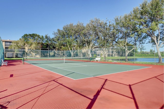 view of tennis court featuring community basketball court and fence