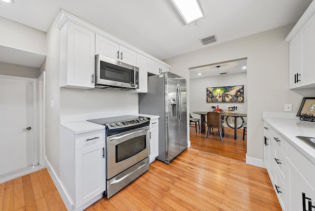 1613 N J Ter, Lake Worth Beach, FL 33460 - kitchen featuring appliances with stainless steel finishes, light wood finished floors, light countertops, white cabinets, and recessed lighting