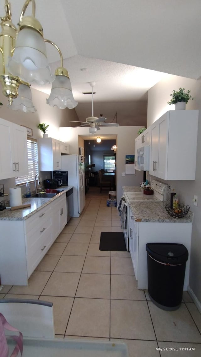 1805 Stonehaven Dr, Boynton Beach, FL 33436 - kitchen with white appliances, light tile patterned flooring, white cabinets, a ceiling fan, and a high ceiling