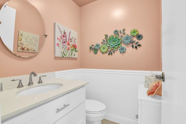 79 Saxony B B, Delray Beach, FL 33446 - bathroom with toilet, wainscoting, vanity, and a decorative wall