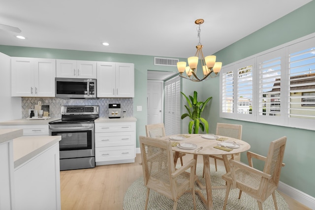 79 Saxony B B, Delray Beach, FL 33446 - kitchen with stainless steel appliances, decorative backsplash, a chandelier, plenty of natural light, and recessed lighting