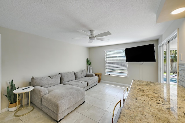 10687 Katmandu Ct, Boynton Beach, FL 33437 - living area with plenty of natural light, a ceiling fan, light tile patterned floors, baseboards, and a textured ceiling