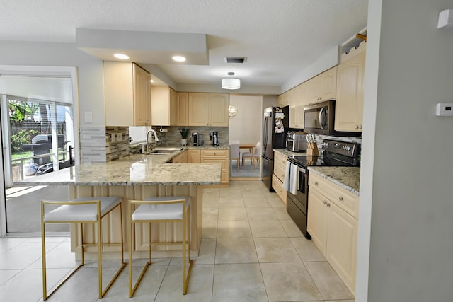 10687 Katmandu Ct, Boynton Beach, FL 33437 - kitchen featuring stainless steel appliances, a peninsula, a sink, decorative backsplash, and light brown cabinets