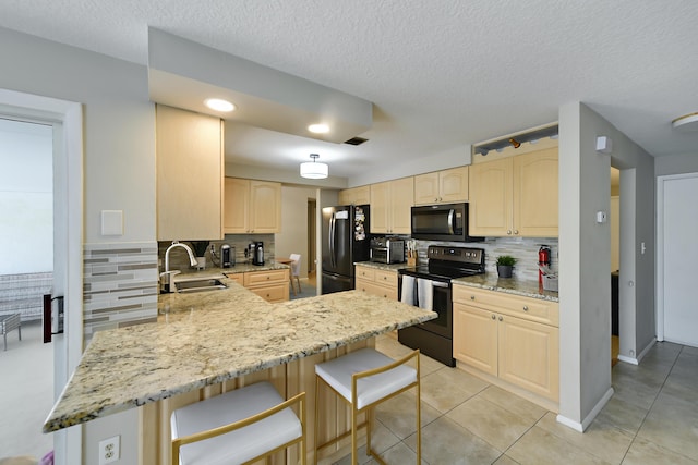 10687 Katmandu Ct, Boynton Beach, FL 33437 - kitchen with stainless steel electric stove, a sink, freestanding refrigerator, light brown cabinetry, and a peninsula