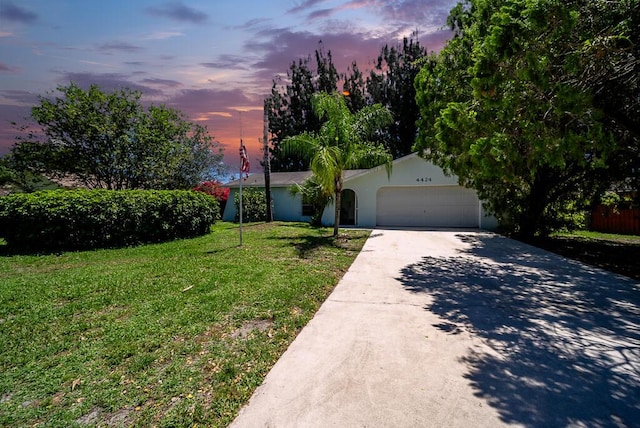 4424 Regency Dr, Lake Worth, FL 33461 - view of front of home with a front yard, driveway, an attached garage, and stucco siding