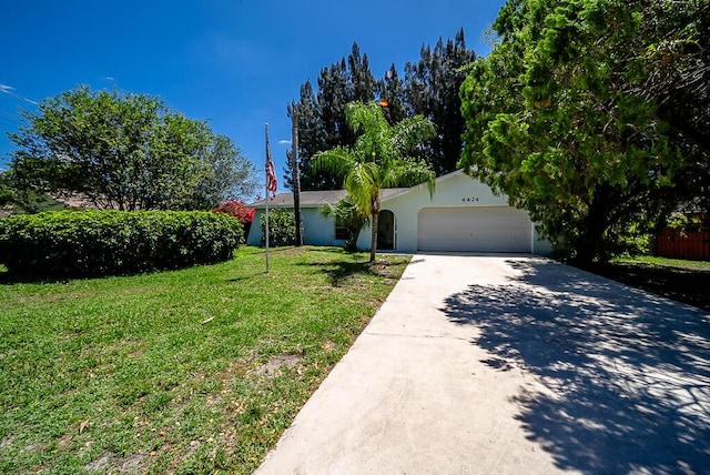 4424 Regency Dr, Lake Worth, FL 33461 - view of front facade featuring an attached garage, driveway, a front yard, and stucco siding