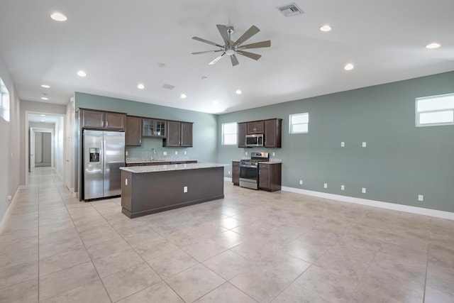 4982 SE Railway Ave, Stuart, FL 34997 - kitchen featuring appliances with stainless steel finishes, a kitchen island, dark brown cabinetry, a ceiling fan, and baseboards