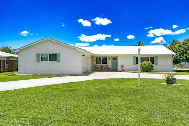 ranch-style house featuring concrete driveway, brick siding, a garage, and metal roof