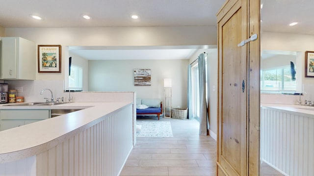 hall featuring a sink, healthy amount of natural light, recessed lighting, and light wood-style floors