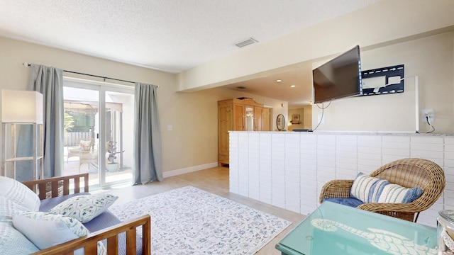 living area with a textured ceiling and baseboards