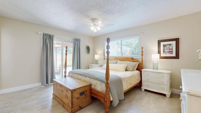 bedroom with light wood-type flooring, baseboards, a textured ceiling, and ceiling fan