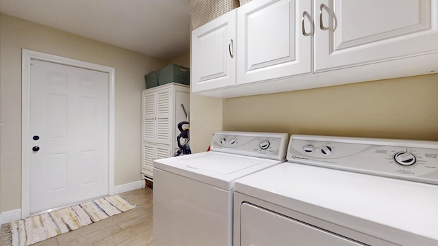 clothes washing area with washer and dryer, cabinet space, and baseboards