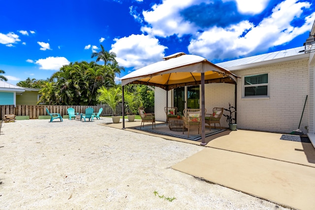 view of patio featuring a gazebo, fence, and an outdoor fire pit