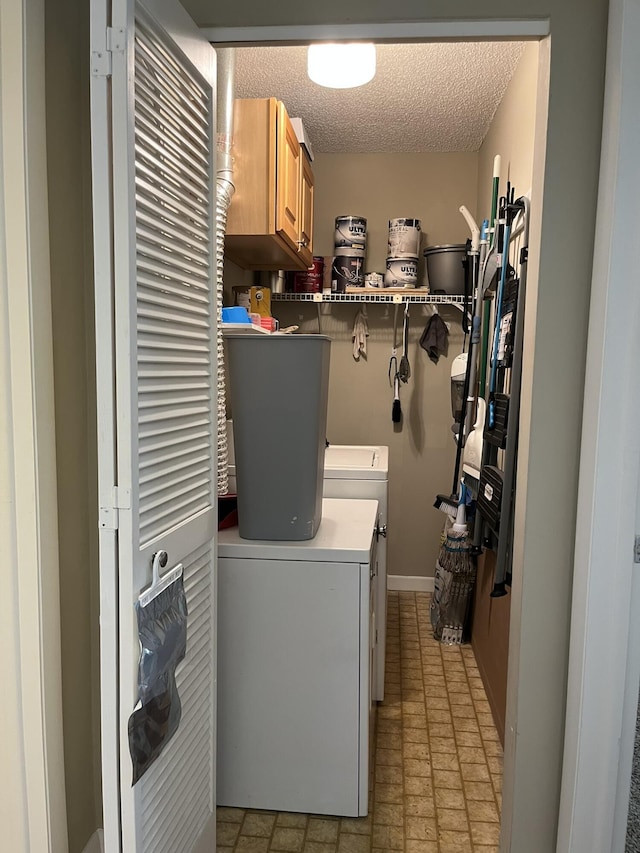 13852 Via Flora Unit A, Delray Beach, FL 33484 - laundry area featuring independent washer and dryer, cabinet space, baseboards, and a textured ceiling