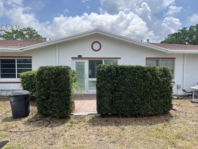 13852 Via Flora Unit A, Delray Beach, FL 33484 - view of side of home featuring stucco siding and roof with shingles
