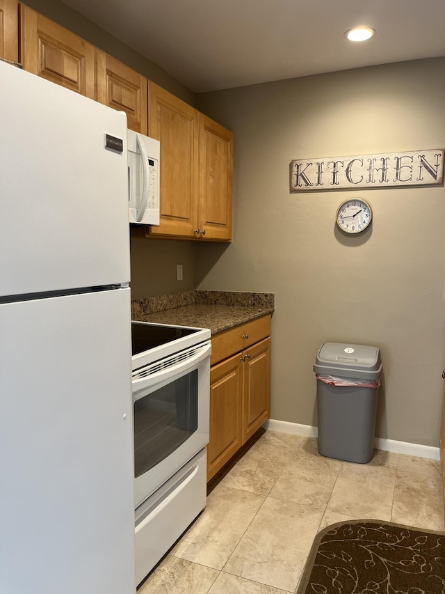 13852 Via Flora Unit A, Delray Beach, FL 33484 - kitchen with white appliances, dark countertops, recessed lighting, baseboards, and brown cabinetry