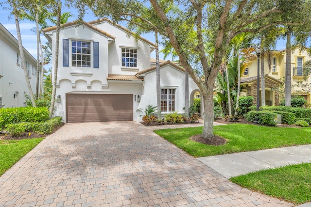 1909 Flower Dr, Palm Beach Gardens, FL 33410 - mediterranean / spanish-style house with stucco siding, decorative driveway, a tile roof, an attached garage, and a front yard