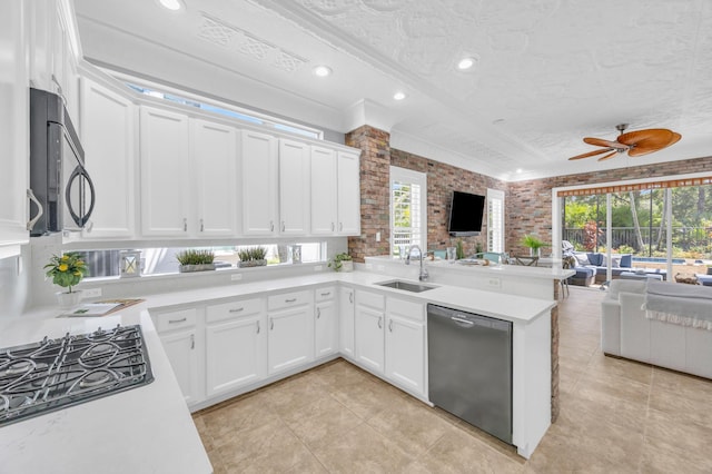 1909 Flower Dr, Palm Beach Gardens, FL 33410 - kitchen featuring black appliances, open floor plan, light tile patterned flooring, light countertops, and brick wall