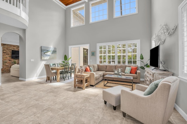 1909 Flower Dr, Palm Beach Gardens, FL 33410 - living area with a high ceiling, arched walkways, healthy amount of natural light, and light tile patterned floors