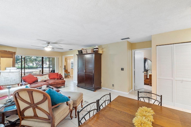 2890 SW 22nd Cir Unit 242B, Delray Beach, FL 33445 - living room featuring light tile patterned floors, baseboards, a textured ceiling, and ceiling fan