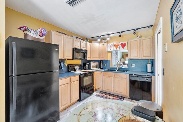2890 SW 22nd Cir Unit 242B, Delray Beach, FL 33445 - kitchen featuring black appliances, light brown cabinetry, a sink, light tile patterned floors, and decorative backsplash