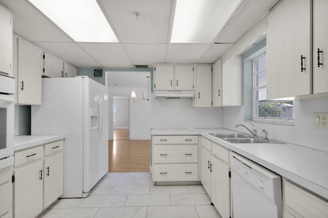 8888 SE Colony St, Hobe Sound, FL 33455 - kitchen with white appliances, a sink, a drop ceiling, under cabinet range hood, and light countertops