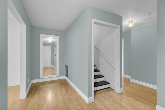 8888 SE Colony St, Hobe Sound, FL 33455 - hallway with light wood finished floors, stairway, and baseboards