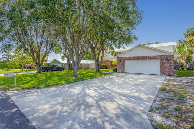 8888 SE Colony St, Hobe Sound, FL 33455 - view of front of home with driveway, brick siding, and a garage