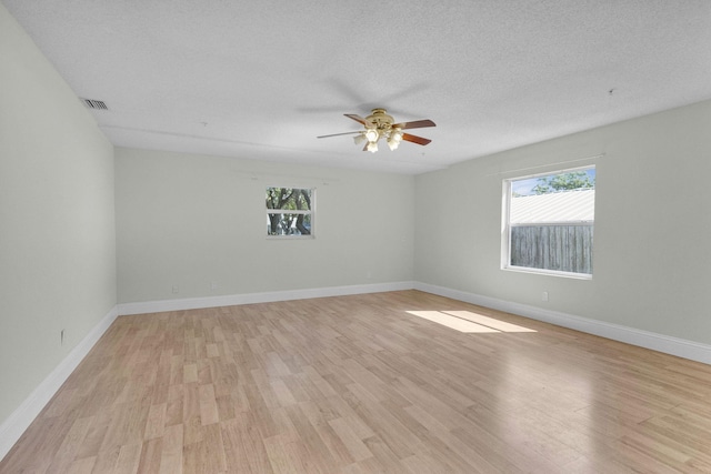 8888 SE Colony St, Hobe Sound, FL 33455 - unfurnished room with healthy amount of natural light, light wood-style floors, a ceiling fan, and a textured ceiling