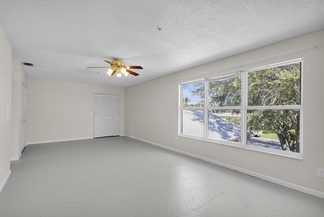 8888 SE Colony St, Hobe Sound, FL 33455 - empty room featuring baseboards, ceiling fan, healthy amount of natural light, finished concrete floors, and a textured ceiling