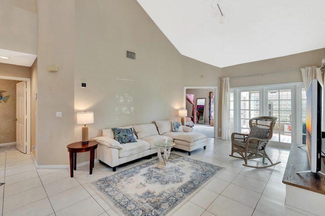 living area featuring high vaulted ceiling, baseboards, and light tile patterned floors