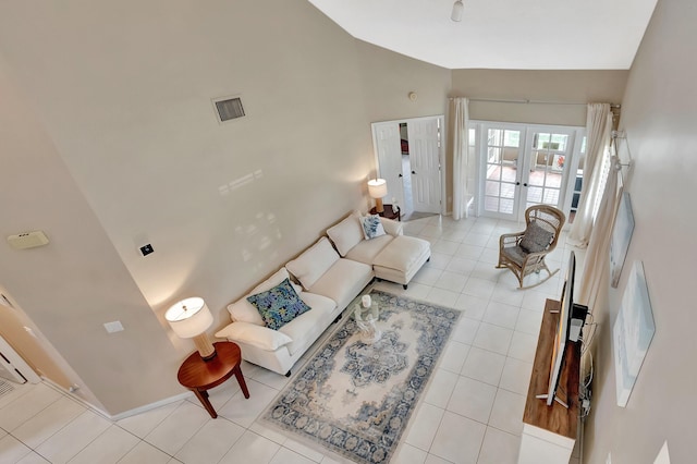 tiled living area featuring french doors and high vaulted ceiling