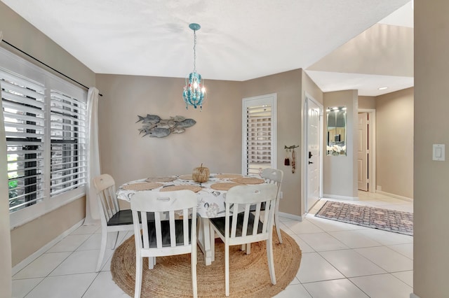 dining room featuring plenty of natural light, a chandelier, light tile patterned flooring, and baseboards
