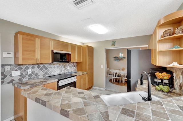 kitchen featuring appliances with stainless steel finishes, light brown cabinets, a sink, backsplash, and open shelves